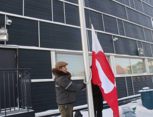 Speaker of the Nunavut Legislative Assembly David Joanasie raises the Greenlandic flag at the territorial legislature on Jan. 20. William Koblensky Varela/NNSL photo